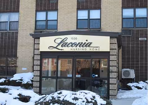 Front entrance of Laconia Nursing Home with snow and brick exterior