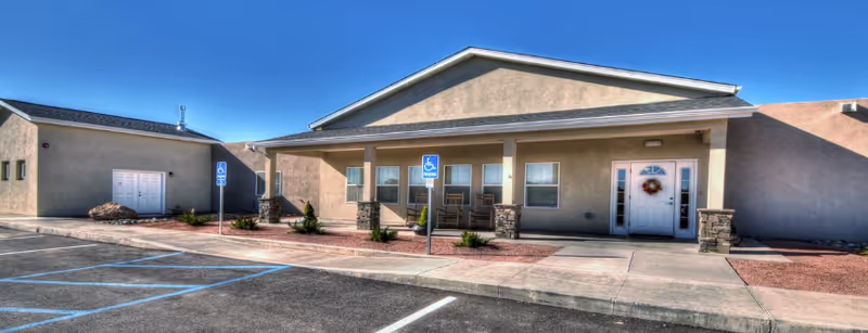 Single-story BeeHive Homes of Gallup exterior with front entrance, handicap parking, and wheelchair sign.
