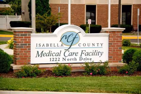 Outdoor brick sign reads Isabella County Medical Care Facility in front of a brick building.