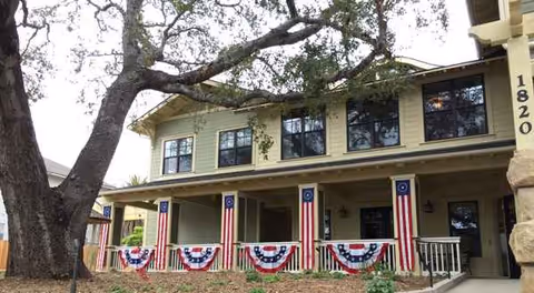 Front exterior of Oak Cottage Memory Care building with patriotic bunting on the porch.