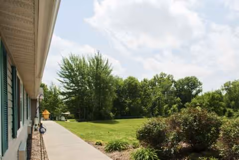 Exterior view of Cedar Creek of Washington facility with walkway, lawn, and trees.