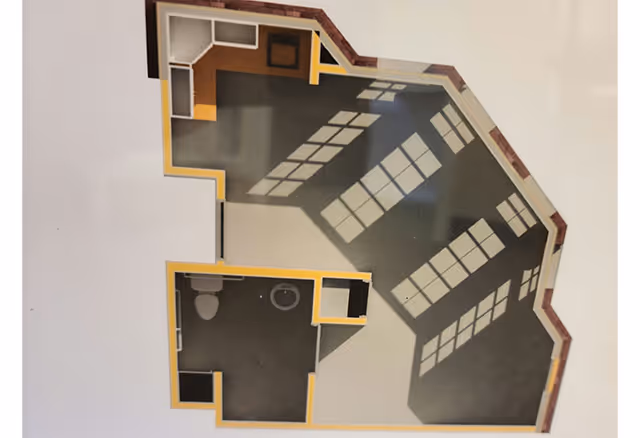 Top-down colored floor plan showing several rooms including a bathroom and a large windowed living area.