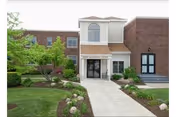 Wesbury United Methodist senior living facility exterior with brick façade, landscaped walkway, and central entrance.