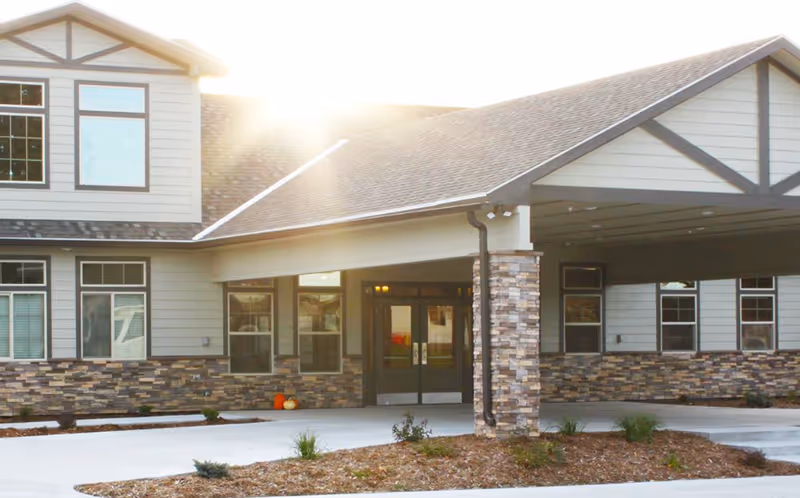 Front exterior of Country Lane Retirement Village showing the entrance with stone veneer and windows.