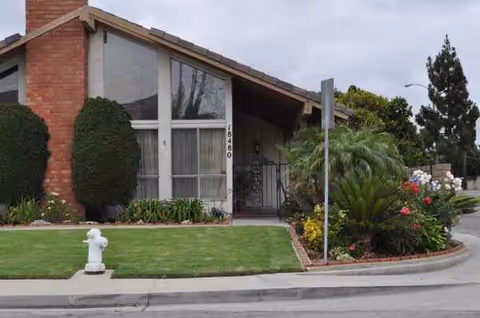 Villa Flora I exterior: a single-story villa-style facility with manicured lawn and garden.