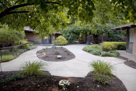 Outdoor courtyard at Altercare Cuyahoga Falls with curved concrete paths and greenery.