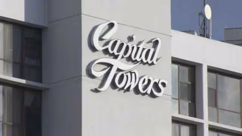 Close-up of the Capital Towers building facade with a large cursive sign.