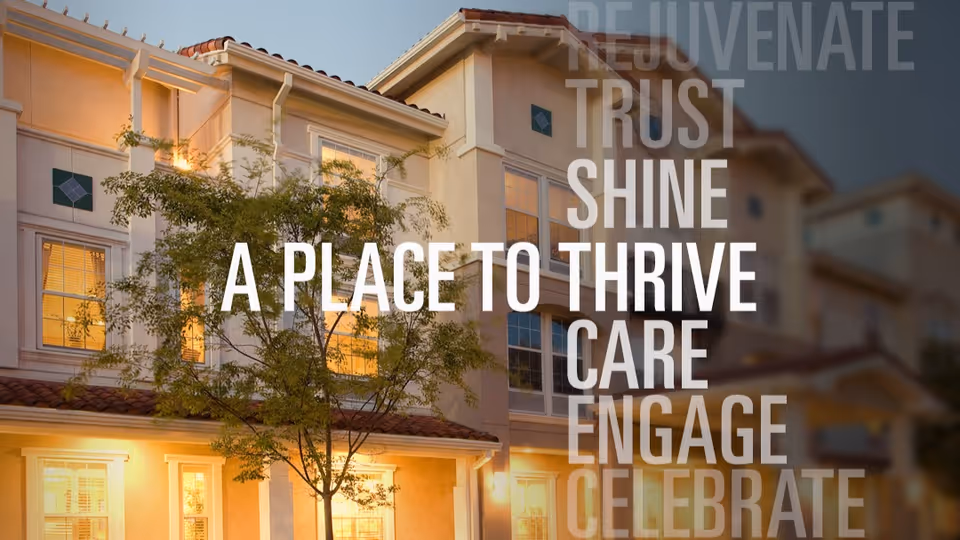 Exterior front of a multi-story senior living building at dusk with warm lit windows and promotional overlay text.