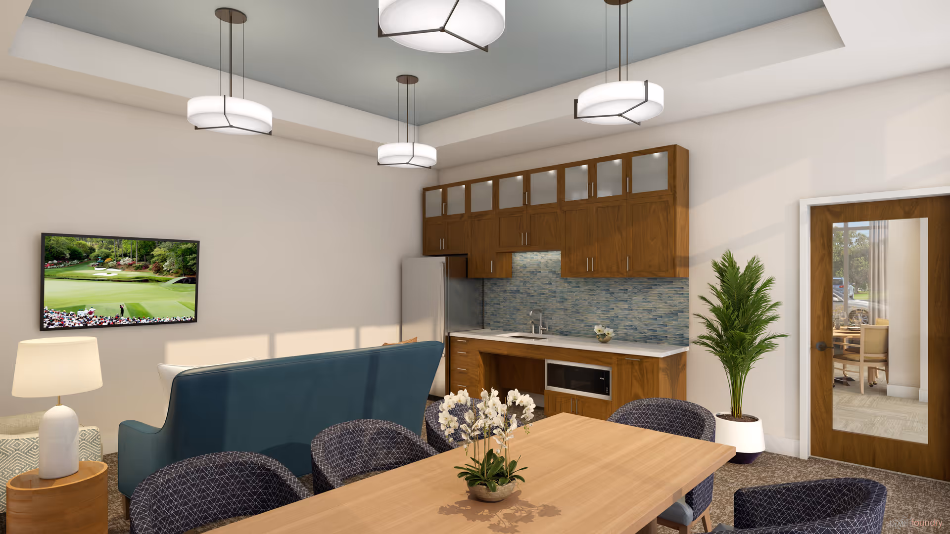 A modern senior living common area featuring a wooden dining table with six patterned chairs, a small potted orchid centerpiece, a blue sofa facing a wall-mounted TV displaying a golf course, a kitchenette with wooden cabinets, a stainless steel refrigerator, microwave, and a blue tile backsplash, a potted plant near a glass-paneled wooden door, and three circular ceiling lights.