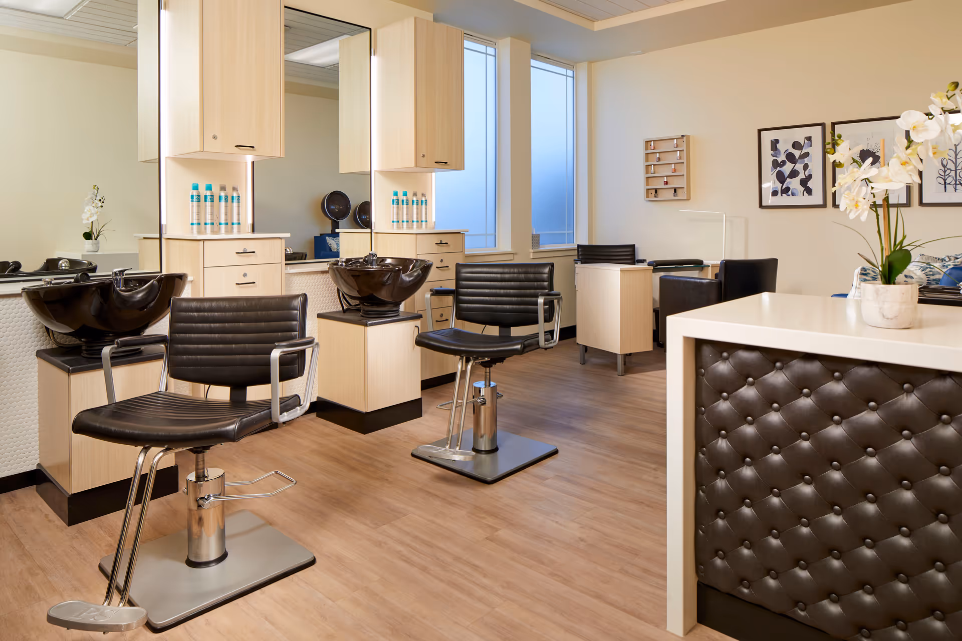 Bright salon interior with styling chairs, shampoo bowls, mirrors, and a reception counter.
