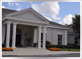 Front view of Conway Lakes Health and Rehabilitation building with columns and landscaping.