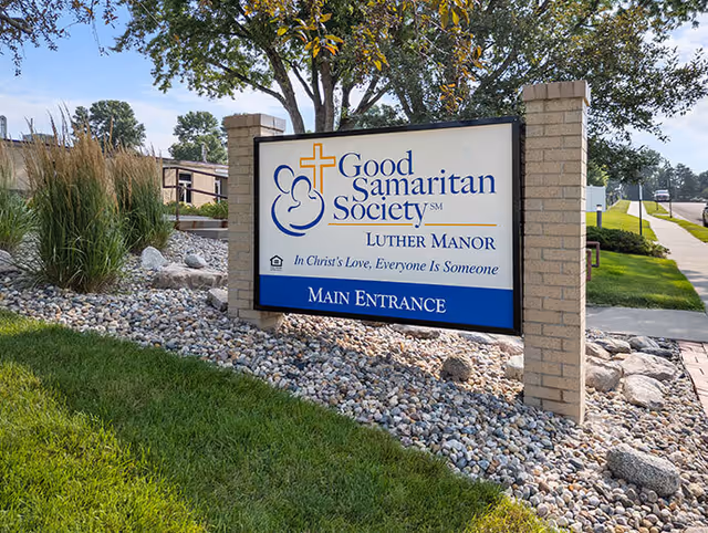 Outdoor landscaped sign reading 'Good Samaritan Society Luther Manor' marking the main entrance.