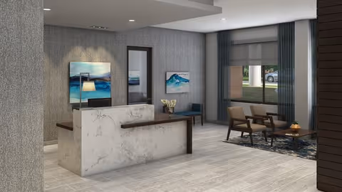 A modern senior living facility reception area with a marble front desk, two abstract paintings on the wall, a small seating area with two chairs and a coffee table, large window with curtains, and neutral-toned flooring and walls.