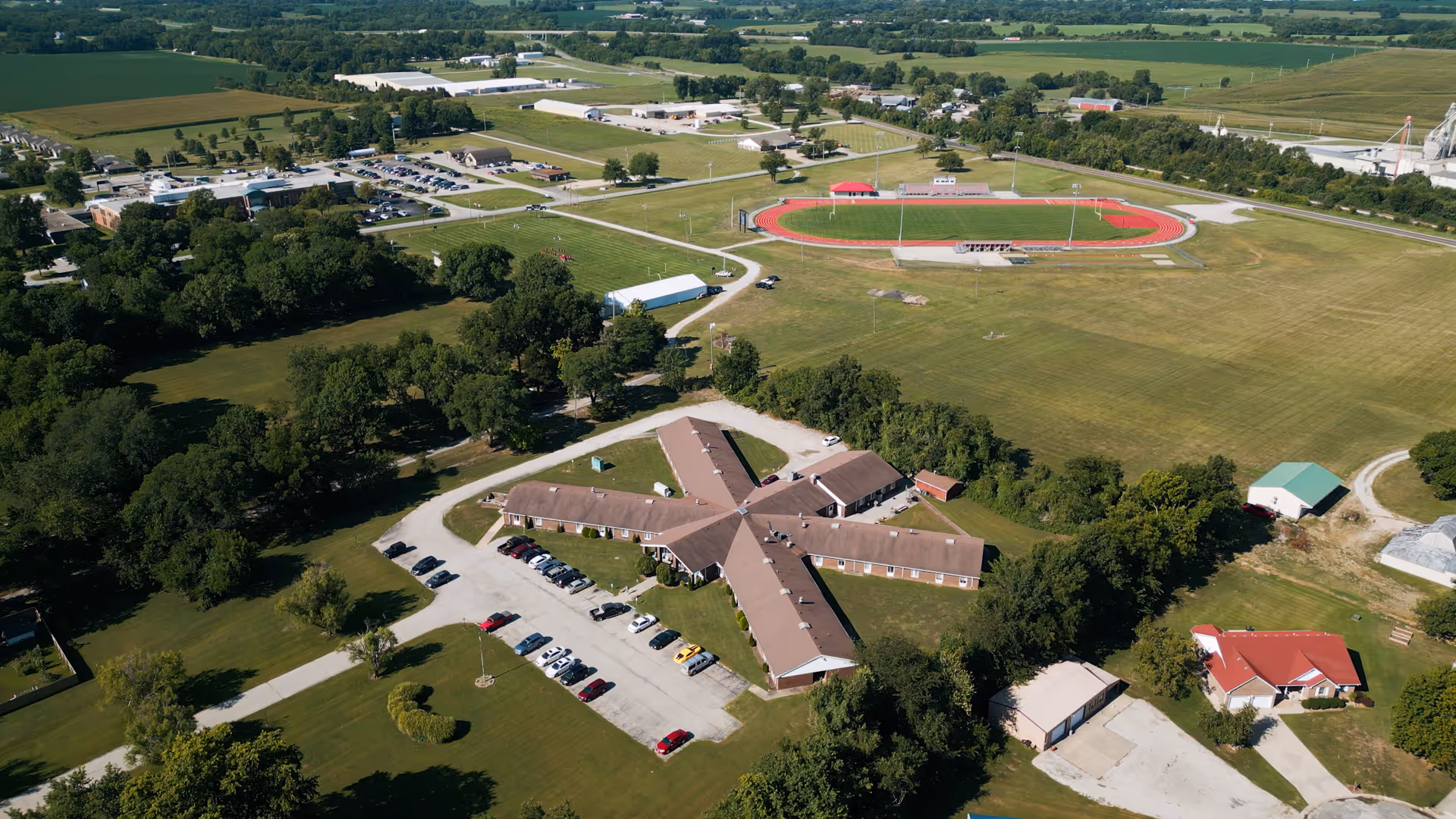Aerial view of Butler Rehab and Healthcare Center surrounded by green fields and a sports track.