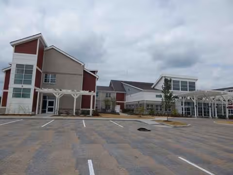 Exterior view of Evergreen Crossing & The Lofts with a spacious parking lot.