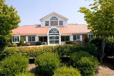 Front view of Alliance Health at Rosewood building with red roof and greenery.