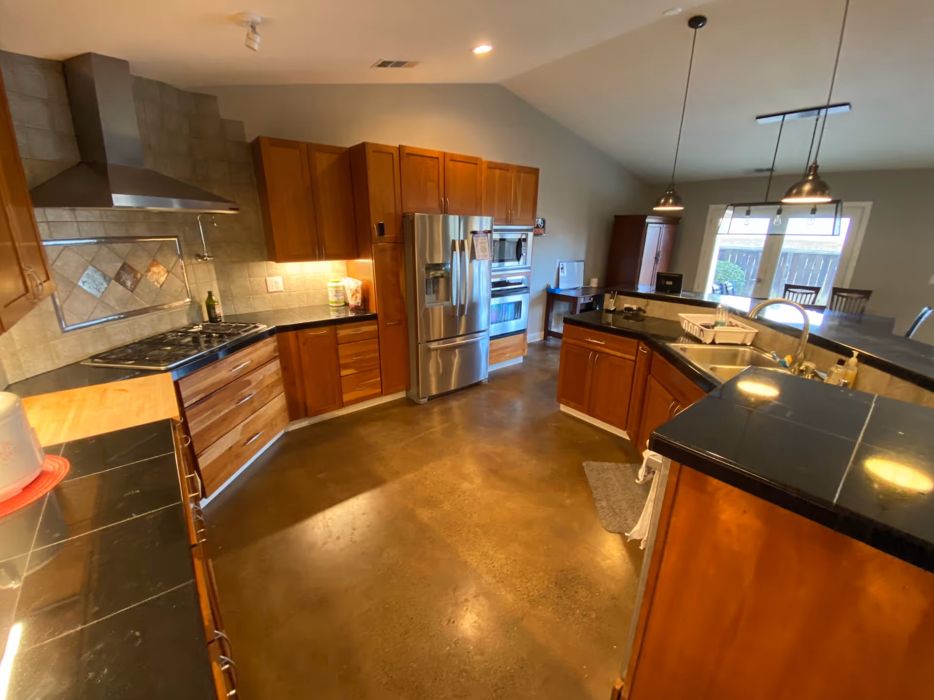 Modern kitchen with wooden cabinets, stainless appliances, and island in a senior living facility.