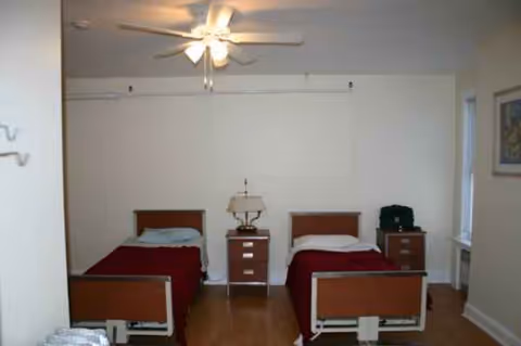 Shared bedroom with two twin beds, nightstands, and a ceiling fan.