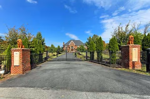 Gated brick entrance leads to a large building at Dominion House of Great Falls