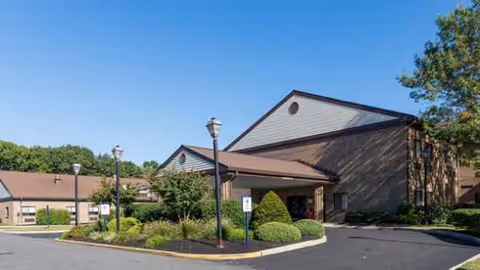 Exterior view of Atlas West Deptford senior living facility with entrance and landscaping.