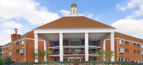 Brick senior living facility Richmond Place with white columns, central portico, and landscaped entrance.