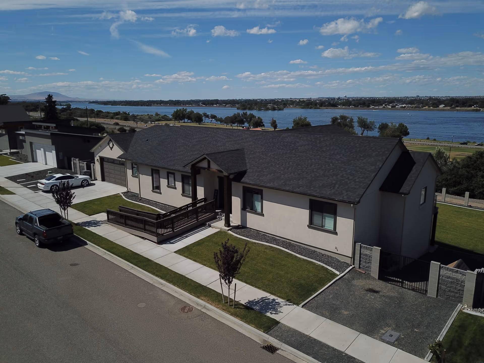 Single-story residential building with a wheelchair ramp, driveway and lawn overlooking a river.