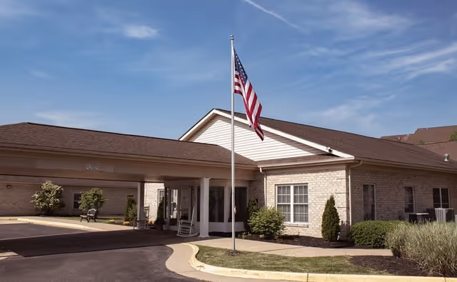 The Maynard senior living facility entrance with a flagpole and landscaped front.
