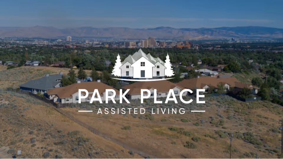 Aerial view of a residential assisted living facility named Park Place Assisted Living, situated on a hillside with a cityscape and mountains in the background.