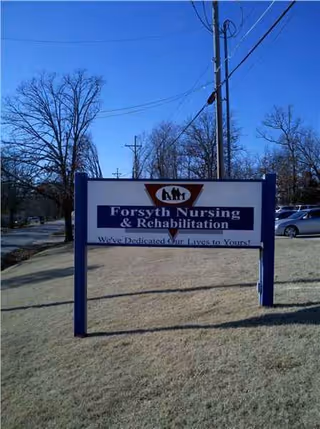 A Forsyth Nursing and Rehabilitation sign on a blue frame in a grassy outdoor area.
