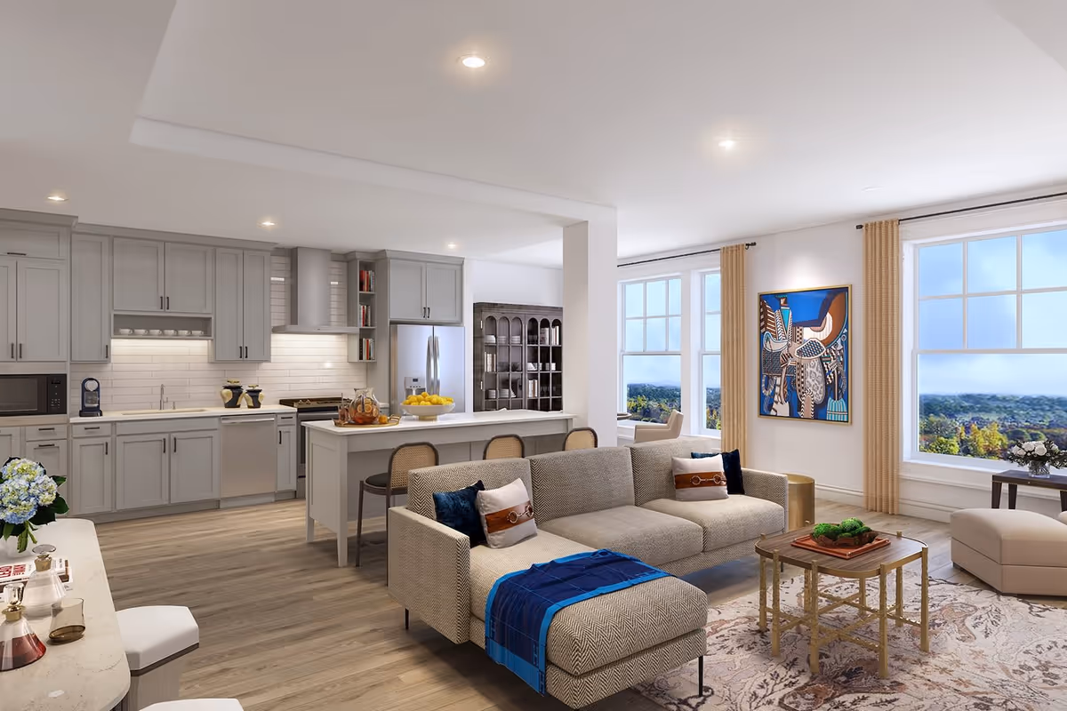 Open-plan living room and kitchen with gray cabinetry, a sectional sofa, island, and large windows overlooking a landscape.