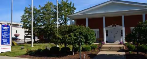 Front entrance of Community Nursing and Rehabilitation with landscaping and sign.