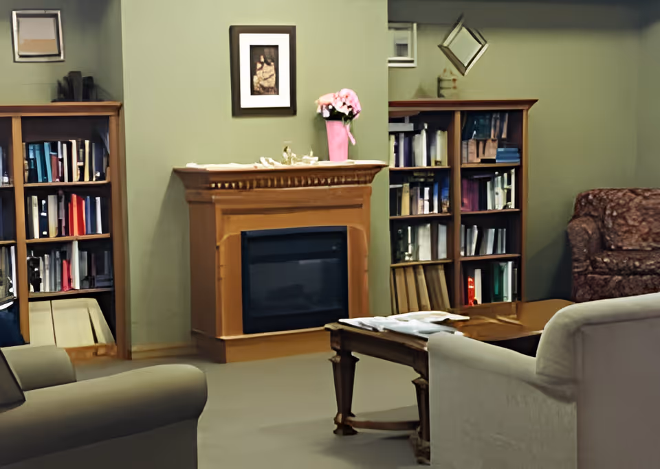 Cozy living room with a fireplace flanked by bookshelves, armchairs and a coffee table.