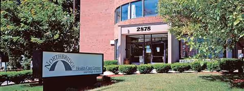 Exterior view of Northbridge Health Care Center entrance with landscaping and a sign.