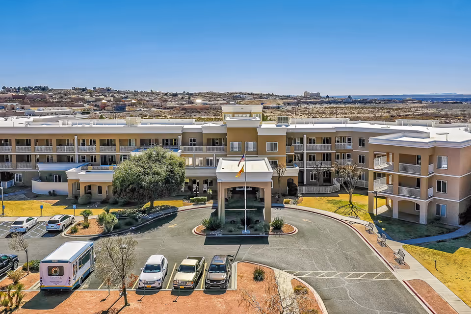 A multi-story Solstice Senior Living at Las Cruces building with circular driveway and flagpole.