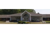 Golden Acres Manor senior living facility with a central entrance and manicured lawn.