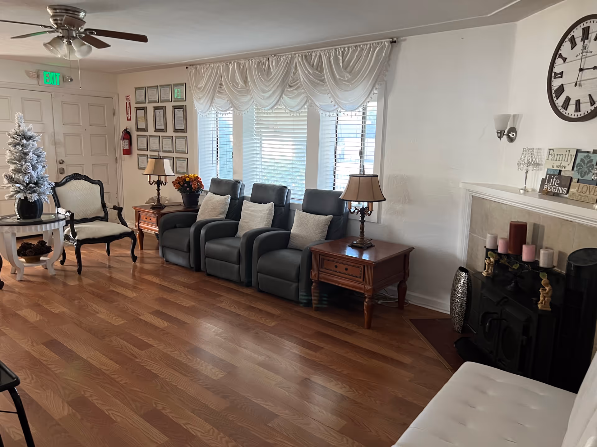 Warm living room lounge with recliners, sofa, lamps, fireplace, and holiday decor.