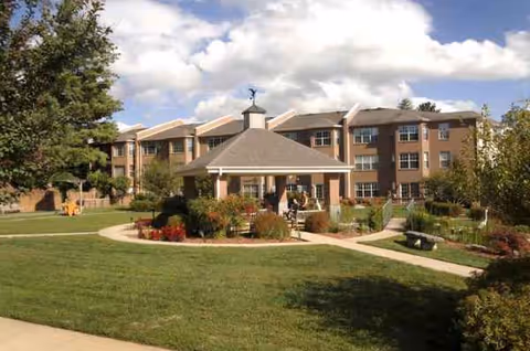 Brick senior living building with a central gazebo in a landscaped courtyard.