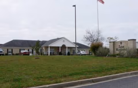 Exterior view of Salem Residential Care Facility with entrance, lawn, and flagpoles.