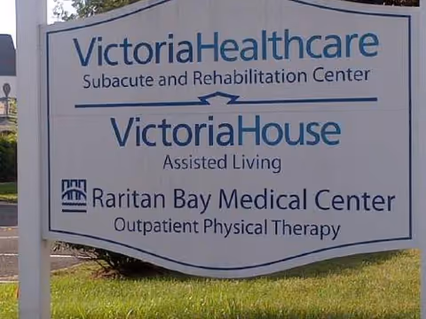Outdoor sign lists VictoriaHealthcare, VictoriaHouse, and Raritan Bay Medical Center on grass.