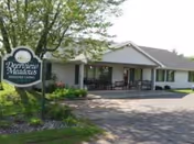 Front exterior of Deerview Meadows Assisted Living with a sign and porch seating.