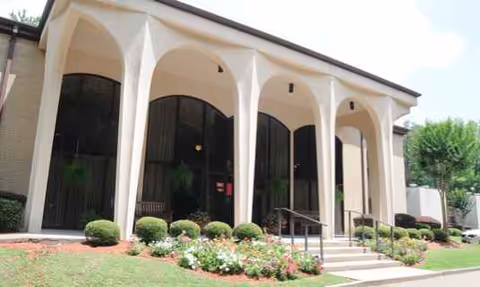 Front facade of Lakeland Nursing & Rehab with arched openings and manicured landscaping.