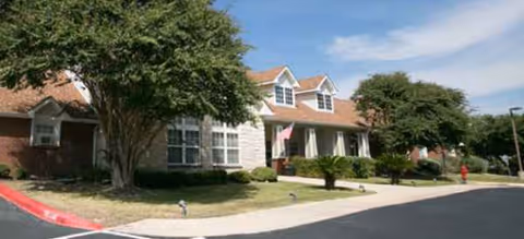 Front exterior of a Brookdale Maltsberger senior living building with trees and a driveway.