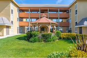 Front exterior of The Orchards Senior Living with a central gazebo and manicured lawn.