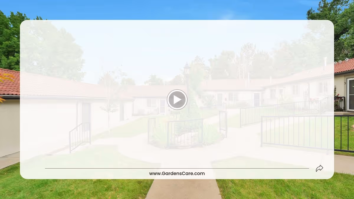 Courtyard with paved paths, grassy lawn, and single-story senior living units with red-tile roofs.