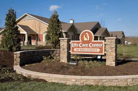Front view of Life Care Center of Rhea County with brick building and landscaped entrance.