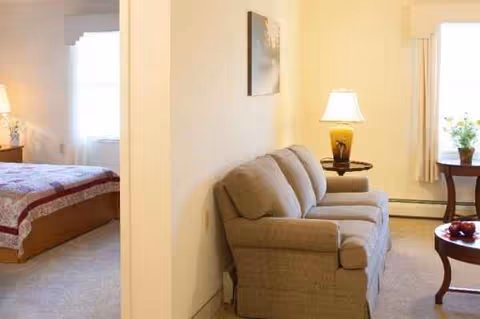 Sofa and coffee table in a beige living room adjacent to a bedroom area.