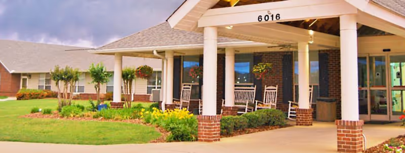 Front entrance of Madison Village senior housing with brick pillars, porch, and benches.