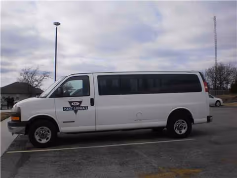 A white Point Lookout van parked in a lot beside a building.