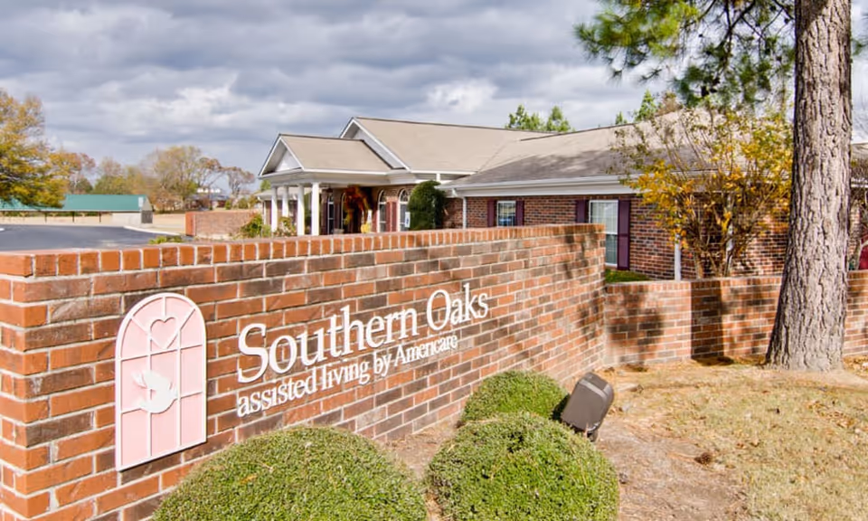 Brick entrance sign reading "Southern Oaks assisted living by Americare" with the facility building and landscaping behind it.