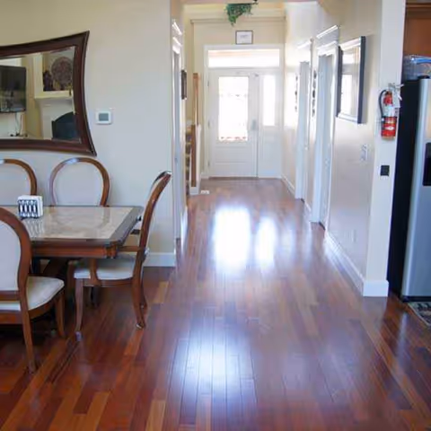 Interior of a senior living home with a dining area and hallway to a door